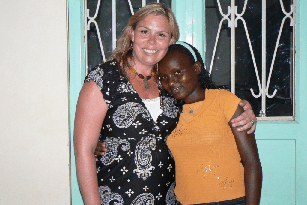 Crisnten poses with a child in Uganda
