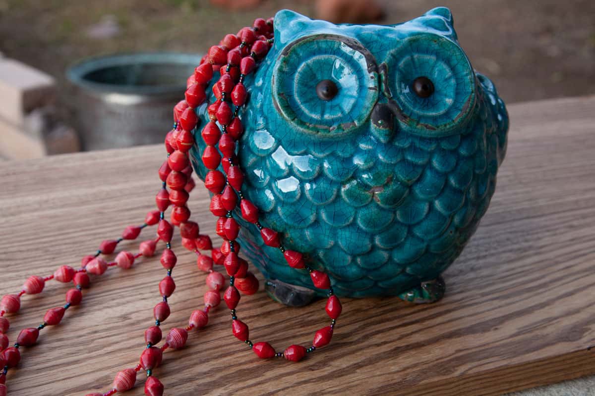 Red beaded necklace and blue owl statue